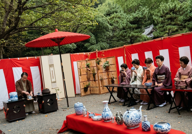 Cérémonie du thé en plein air au jardin Sankei-en, sous une ombrelle rouge : mon beau-père, à gauche, prépare le thé pour des invités en kimono